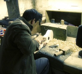 Craftsmen begin the process of sanding the ukeleles.